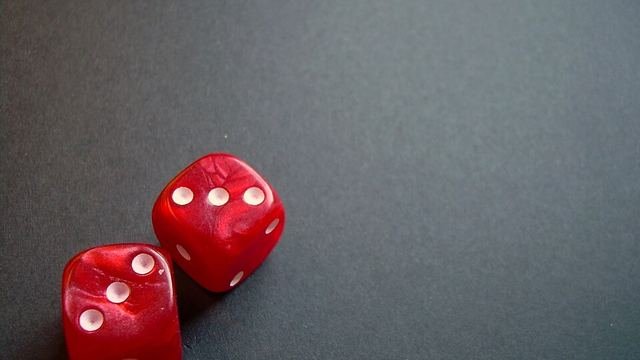 Two red dice on a dark table